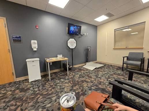 A clinic room retrofitted with a stand-alone floor scale beside the exam chairs