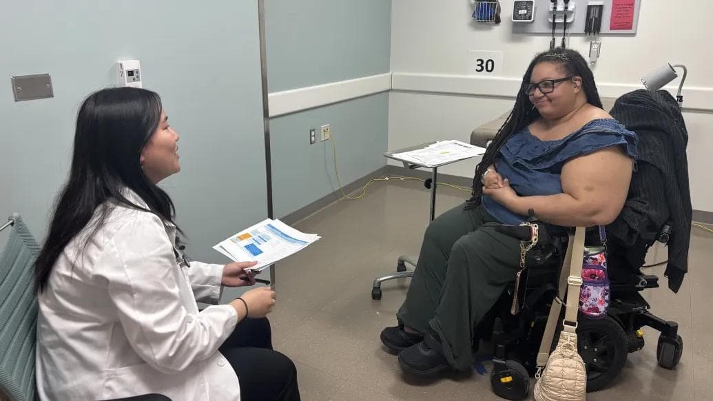 A clinician reviewing results with a wheelchair user in an exam room