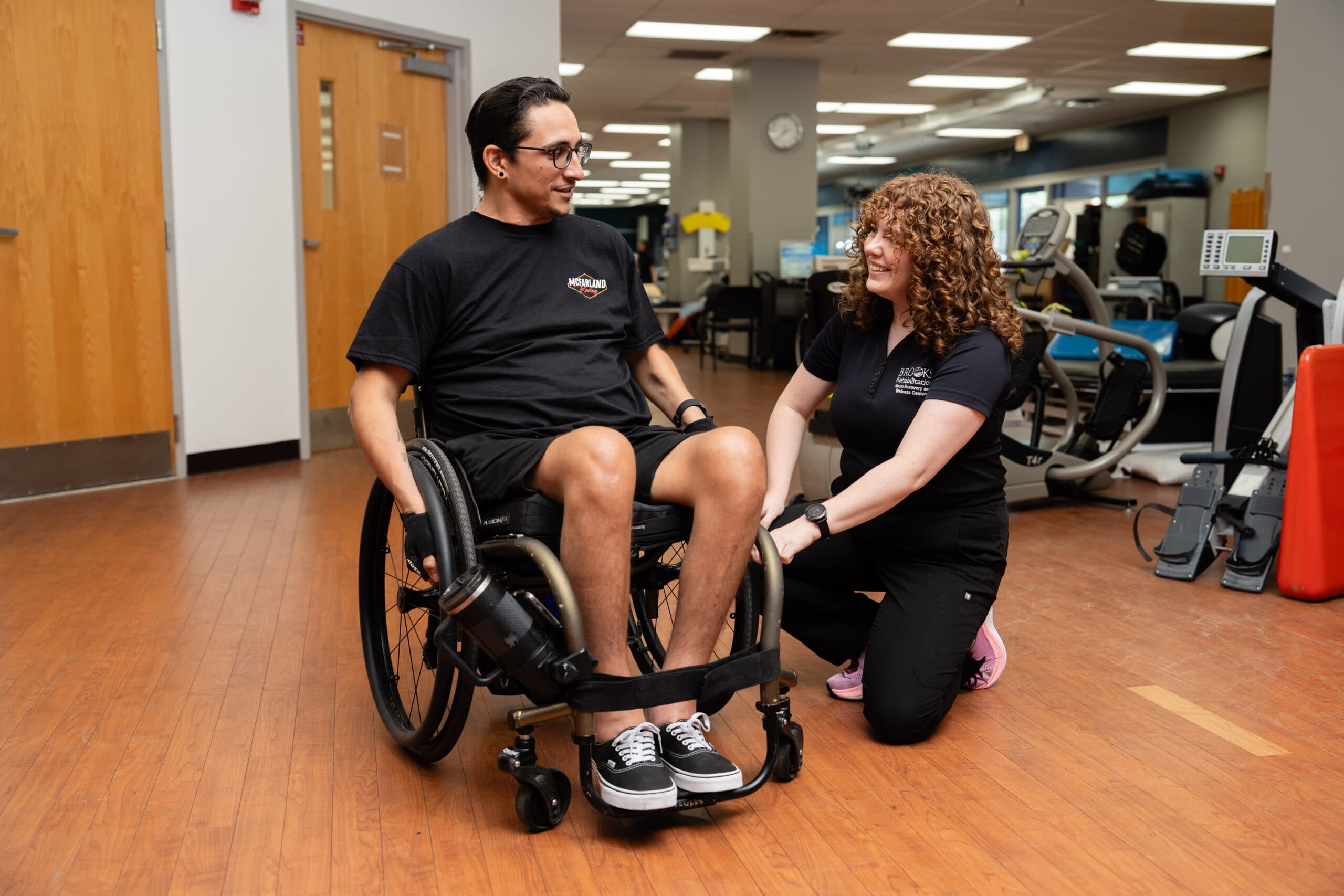 A physical therapist working with a wheelchair user during a seating and mobility assessment